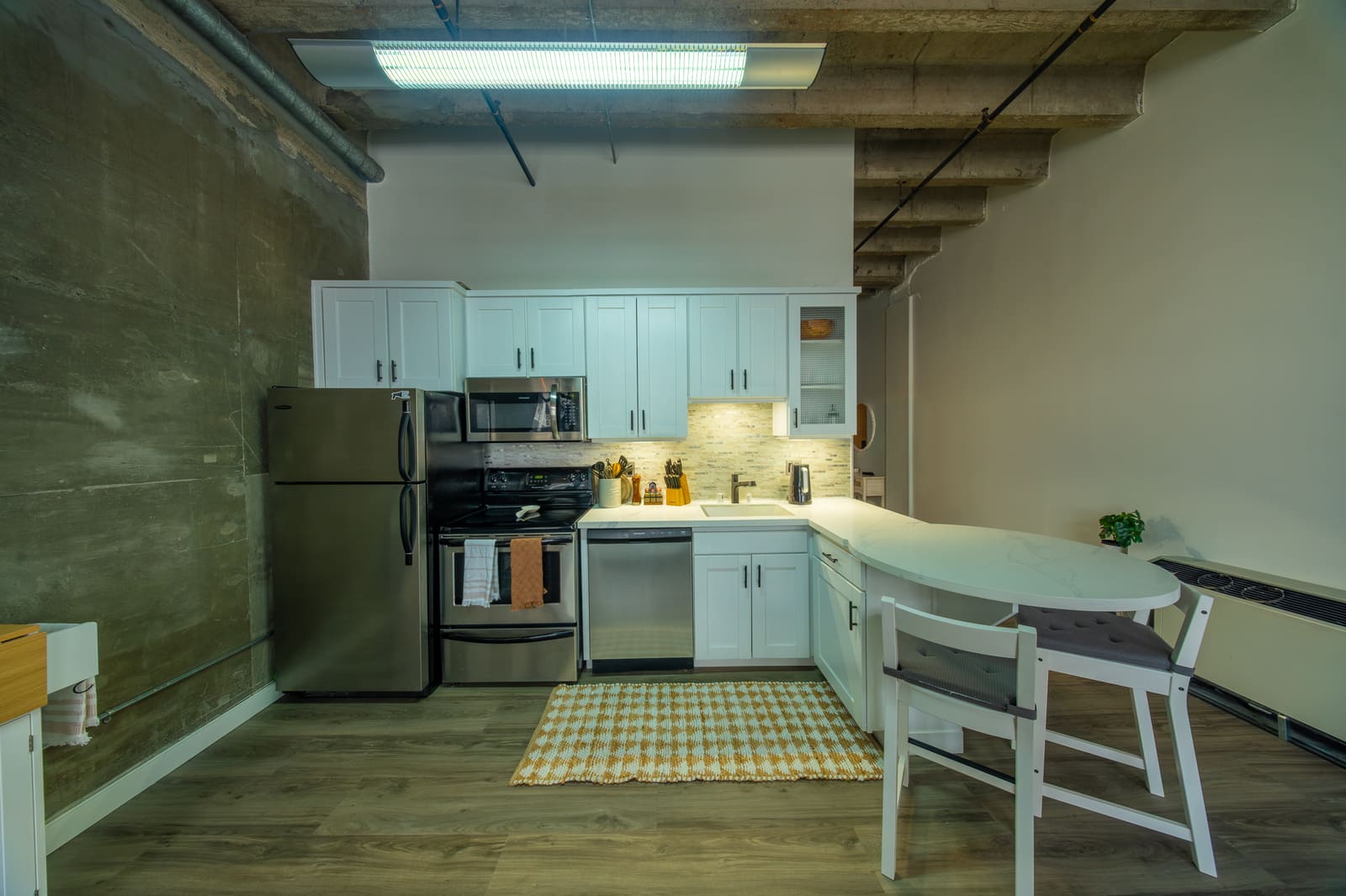 Full kitchen with stainless appliances and dining seating