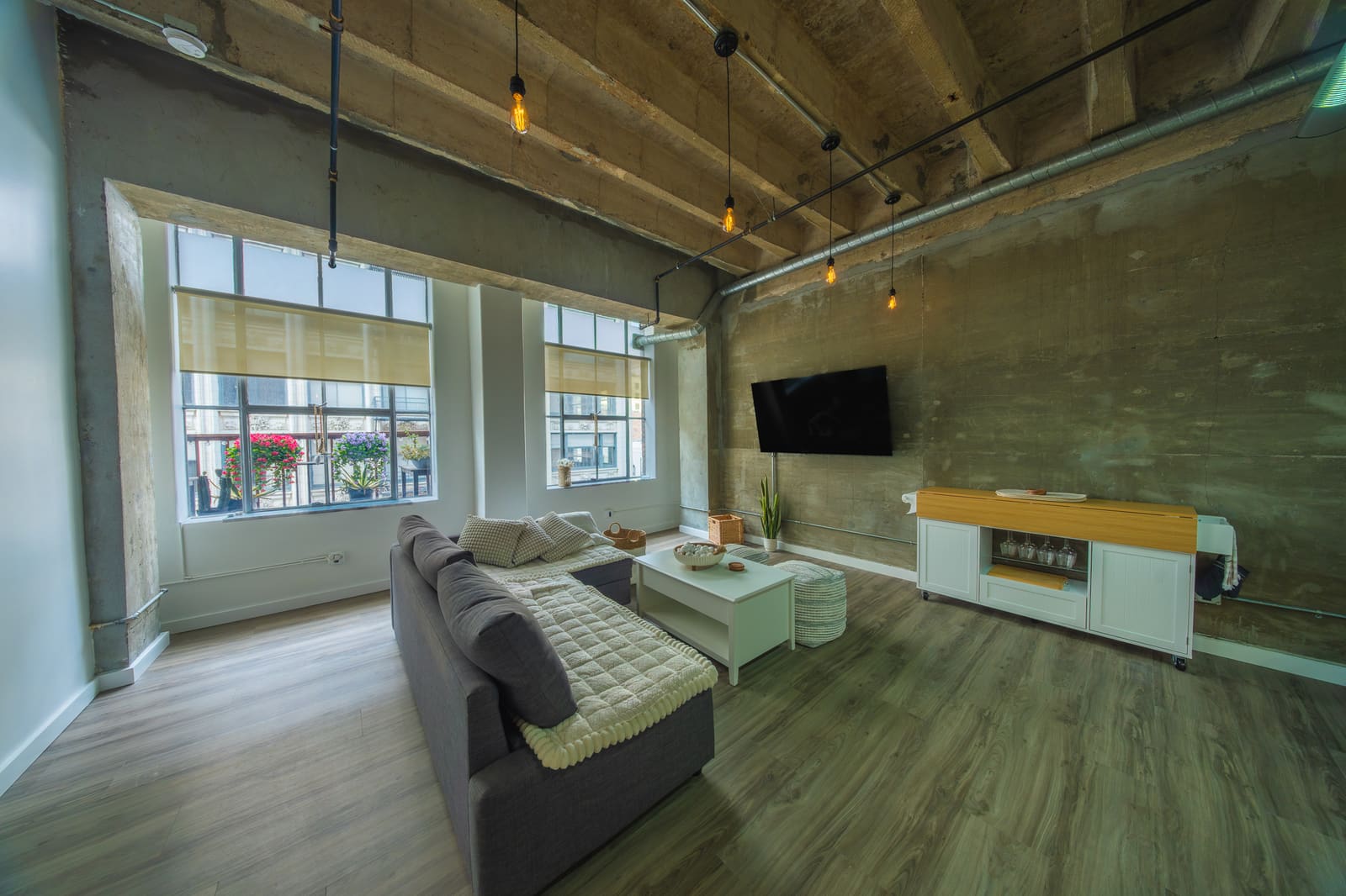 Open loft living area with sectional sofa and concrete-and-steel industrial detailing